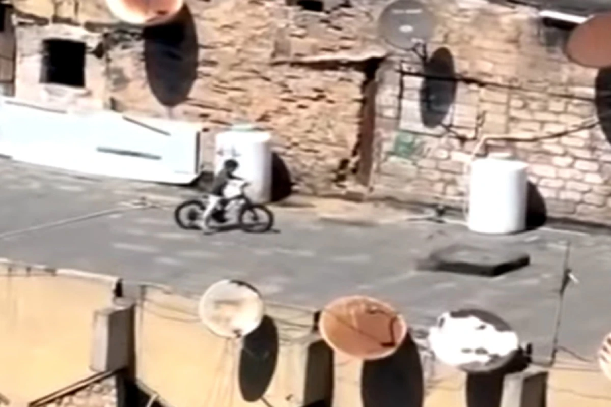 Bakıda uşaqlar binanın damında [[velosiped SÜRÜR]]